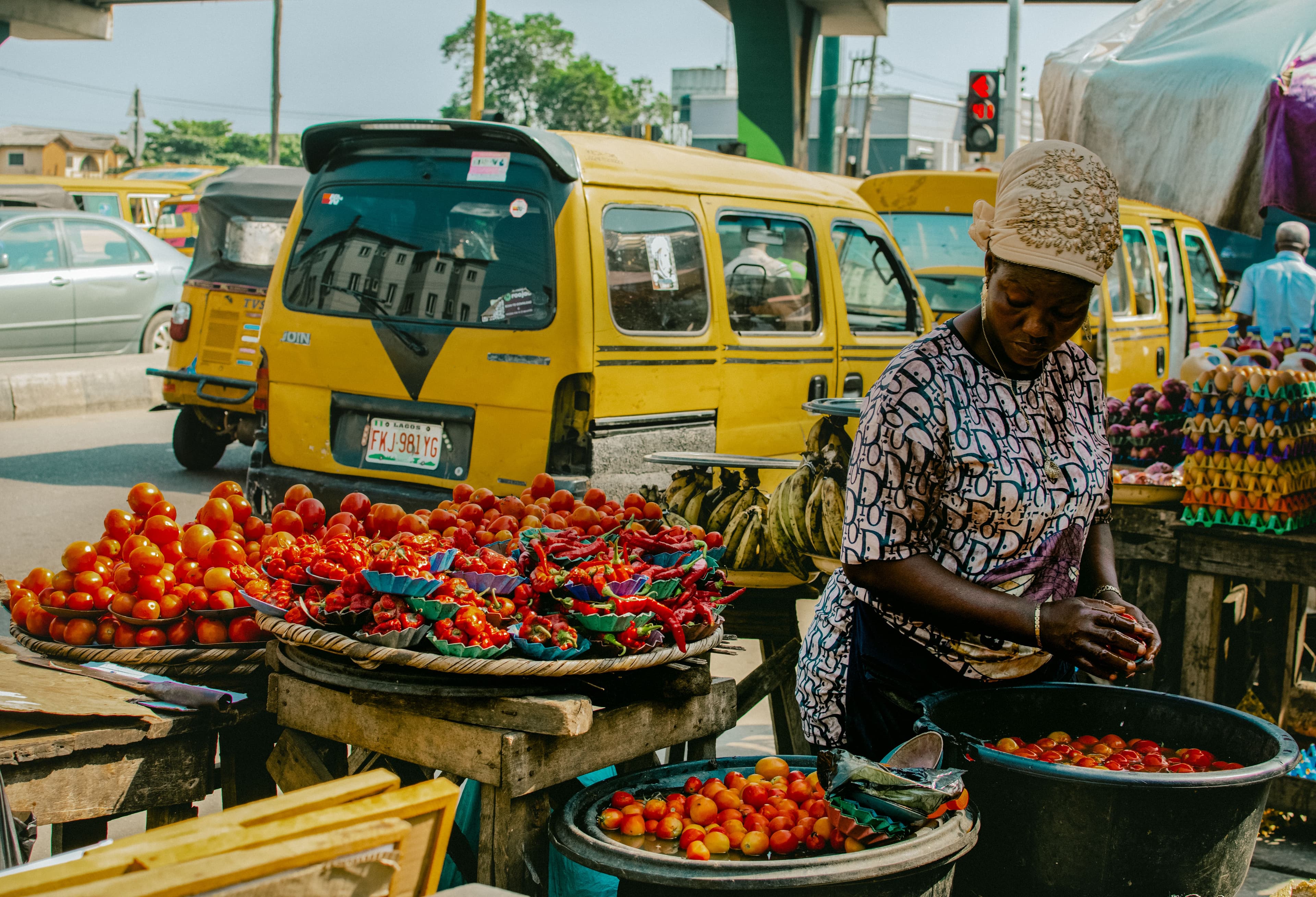 Fresh tomatoes and peppers arranged in baskets at an outdoor market